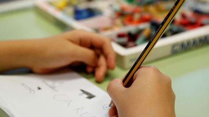 Un niño dibuja en clase.