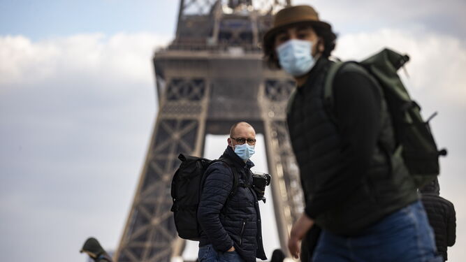 Varias personas con mascarilla en la Torre Eiffel, en París.