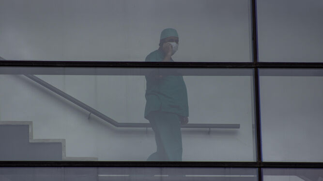 Un enfermero habla por su móvil en el Hospital San Cecilio de Granada