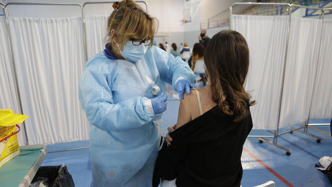 Una enfermera vacuna una dosis de AstraZeneca a una mujer.