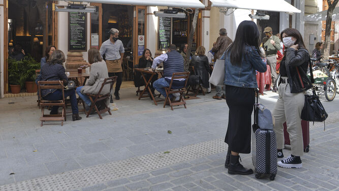 Dos turistas con maletas por las calles de Sevilla.