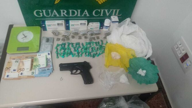 Droga, dinero y el arma incautados por la Guardia Civil.