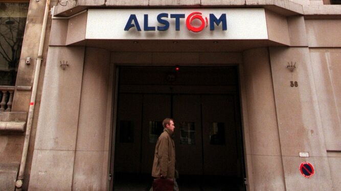 Un hombre camina delante de la sede en París de Alstom.