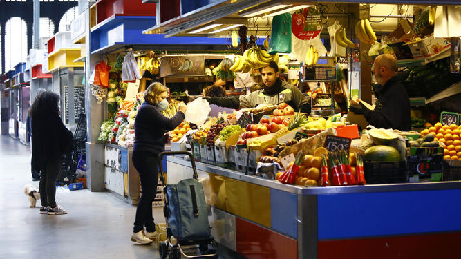 Una mujer compra fruta en uno de los tradicionales mercados de abastos de Málaga.