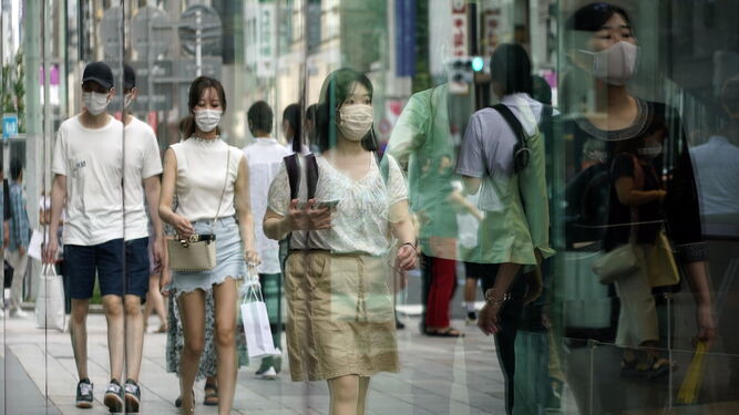 Personas pasean con mascarilla por Tokio.