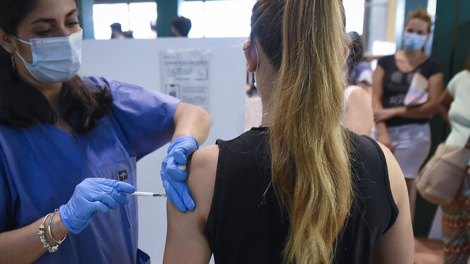 Una enfermera vacuna a una adolescente en Sevilla.