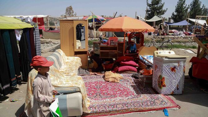 Una familia que planea abandonar Afganistán pone en venta objetos en un mercadillo local, ayer en Kabul.