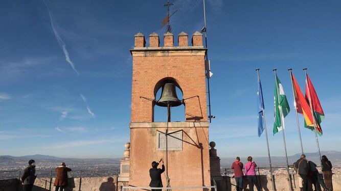 Un trabajador de la Alhambra hace sonar la campana de la Torre de la Vela para mantener la tradición.
