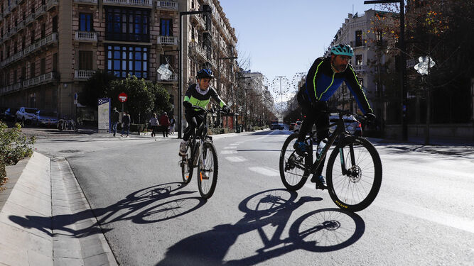 Un padre y su hijo estrenan equipación ciclista (y parece que también bicicleta) por Gran Vía.