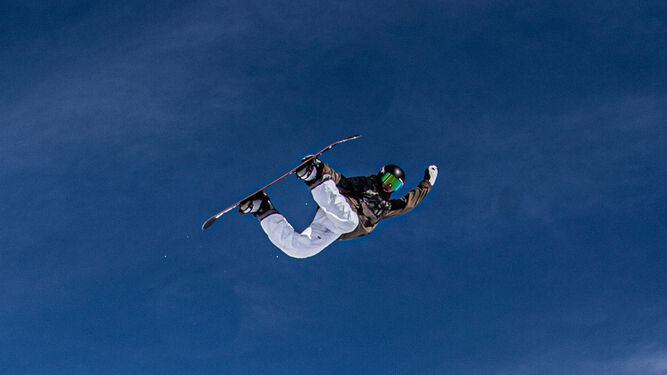 Josito Aragón con su tabla de snowboard en pleno salto.