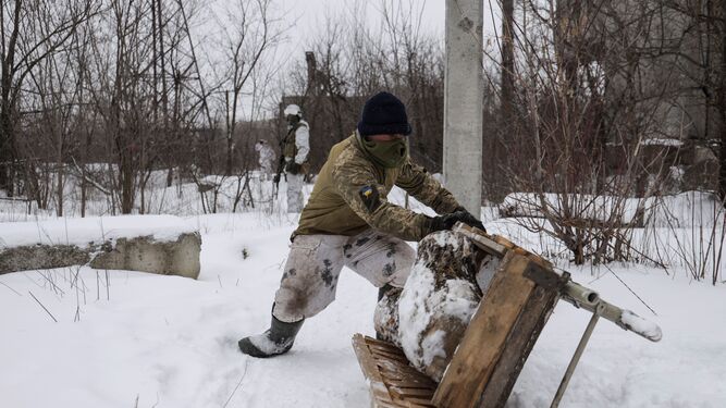 Un soldado ucraniano desliza una carretilla cerca de la frontera donde están desplegadas las fuerzas rusass