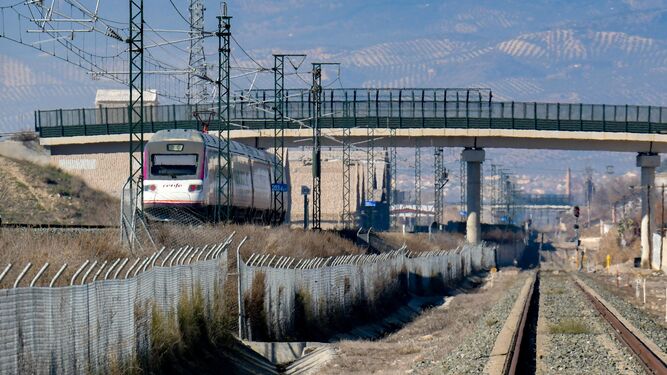 Un tren Avant con destino Sevilla circula por la línea de Alta Velocidad, al lado de la inutilizada vía convencional