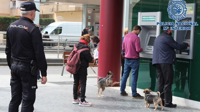 Un agente de la Policía Nacional de Granada custodia los cajeros de una sucursal bancaria