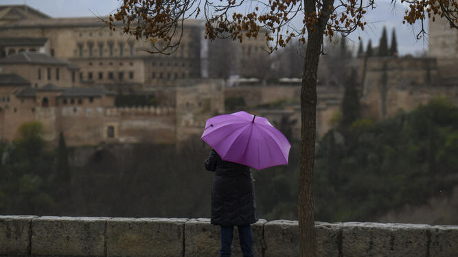 Una persona se resguarda de la lluvia.