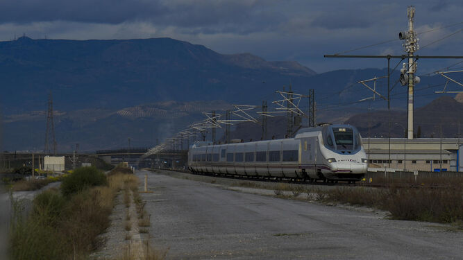 Un tren AVE discurre por la bifurcación de La Chana junto a la plataforma para la doble vía en Granada