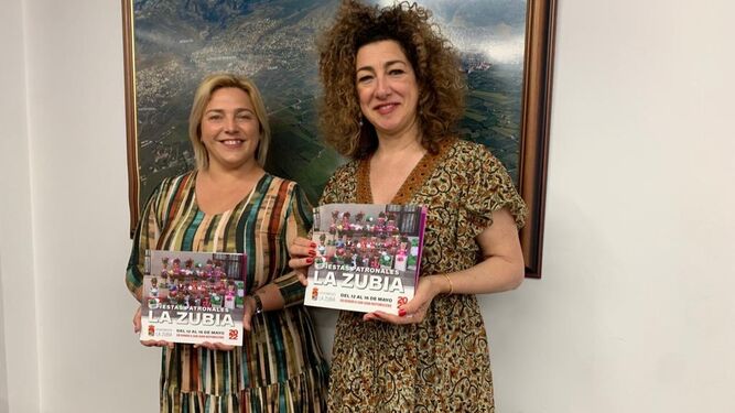 La alcaldesa y la concejala de Fiestas de La Zubia posan con el cartel de las fiestas