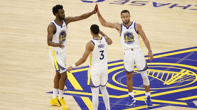 Curry celebra con dos compañeros la victoria.
