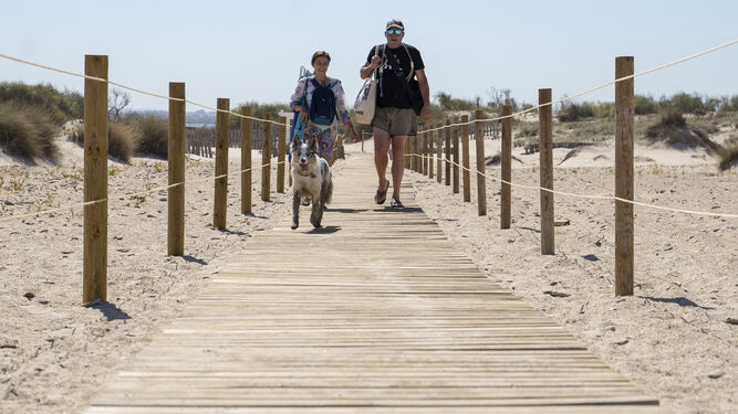 Usuarios por una de las nuevas pasarelas de acceso a la playa canina de Camposoto.