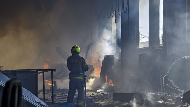 Un bombero trata de apagar el fuego provocado por un bombardeo en un área industrial de Jarkov.