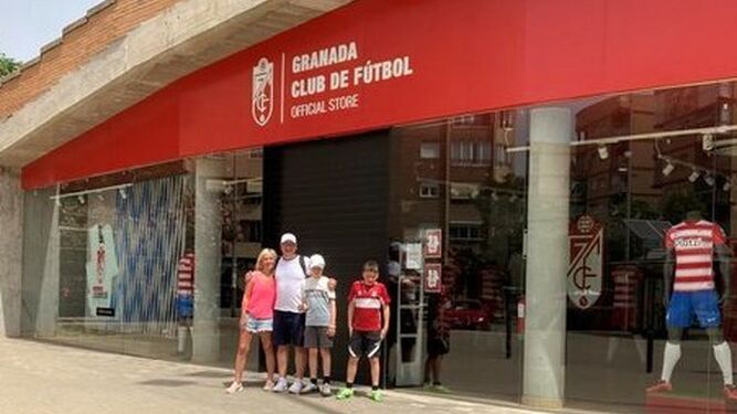 El aficionado del Boro y su familia ante la tienda cerrada del Granada CF