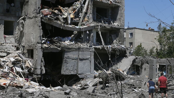 Residentes observan los daños causados en un edificio residencial en un pequeño pueblo cercano a Odesa.