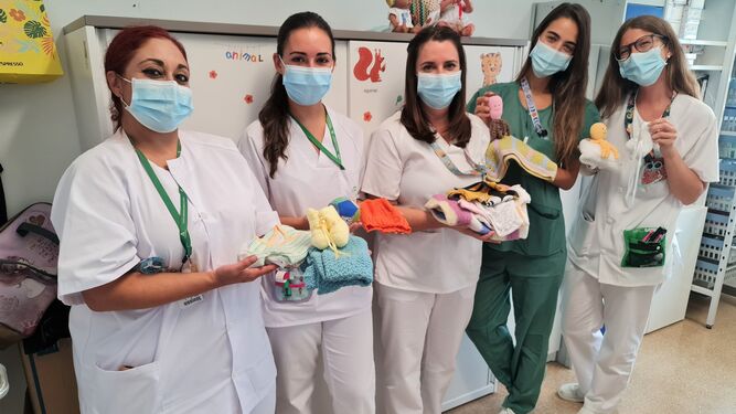 Enfermeras de la unidad Neonatal del Hospital San Cecilio posa con las ropas guardadas en el armario solidario de la unidad