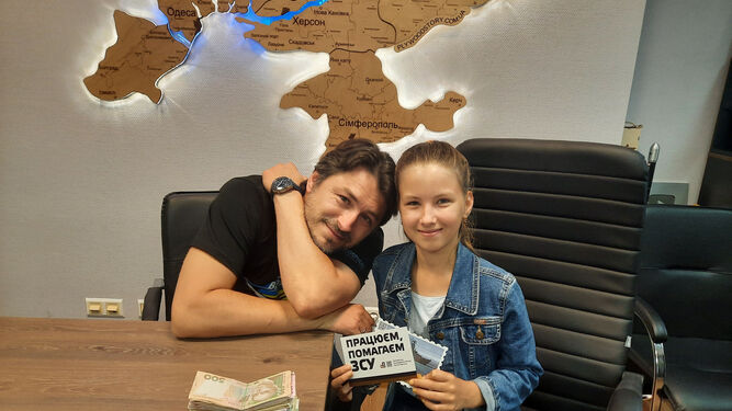 Sergiy Prytula, presentador y fundador de una organización benéfica, recibe un donativo de Valeriia Yezhova, campeona mundial de damas.