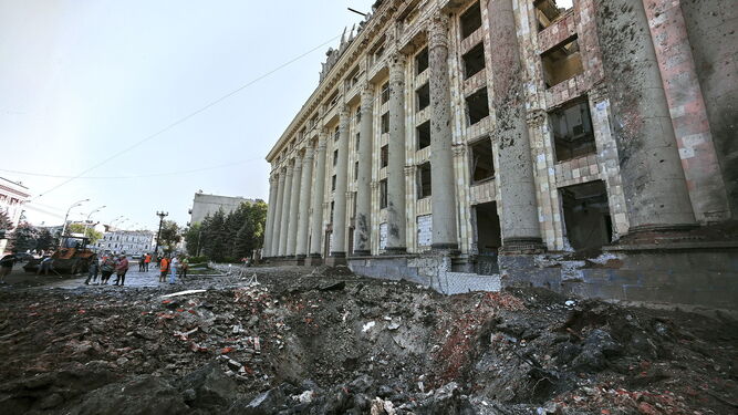 Operarios revisan los daños provocados por un cohete ante un edificio de la Administración regional en Jarkov.