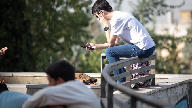 Un estudiante consulta su teléfono móvil.