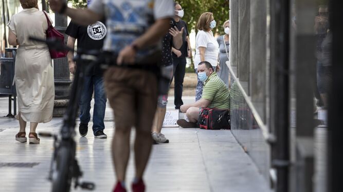 Un hombre pide en las calles de Granada