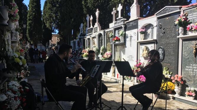 Un pequeño grupo de música toca en el cementerio de Cúllar Vega