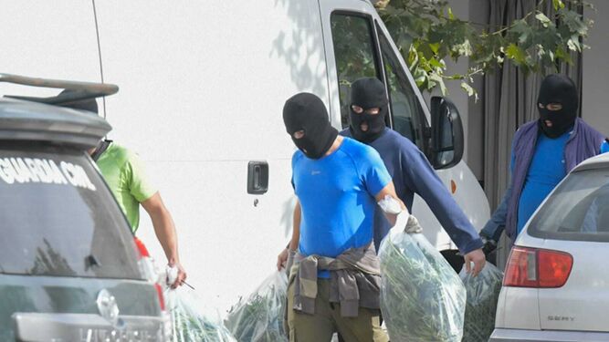 Agentes abandonan una vivienda intervenida con bolsas incautadas llenas de droga