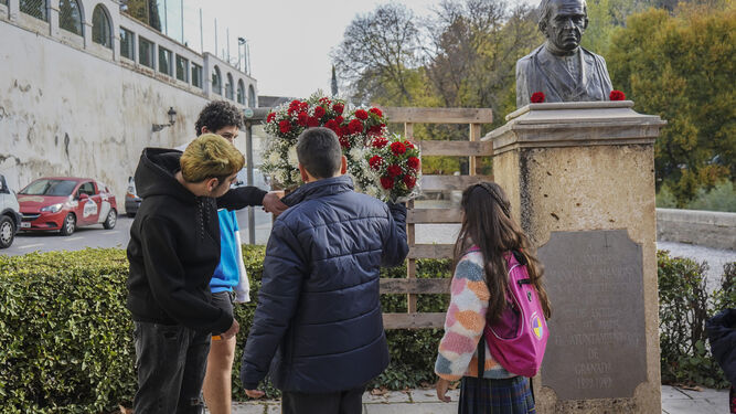 Un grupo de alumnos ofrece flores al busto del Padre Manjón