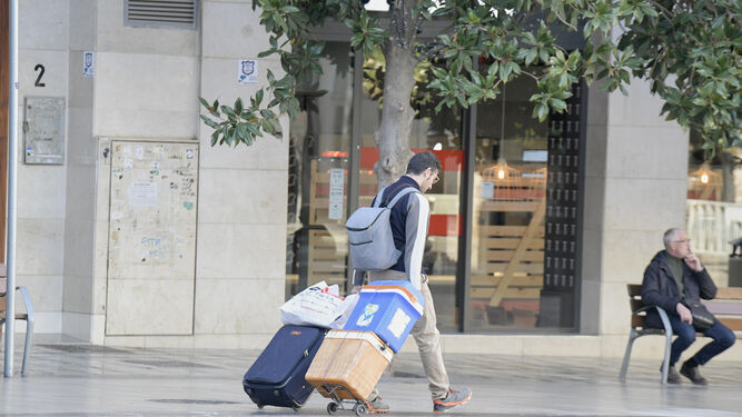 Un turista camina por la Plaza del Carmen de Granada con su equipaje