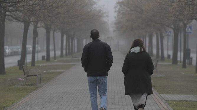 Dos personas caminan por la Avenida Luís Miranda Dávalos contemplando la niebla