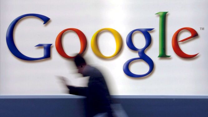 Un hombre camina junto al logotipo de Google
