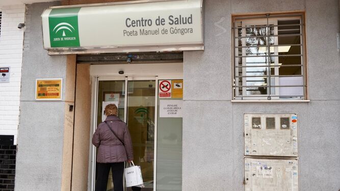 Una usuaria lee un cartel a las puertas de un centro de salud de Granada capital
