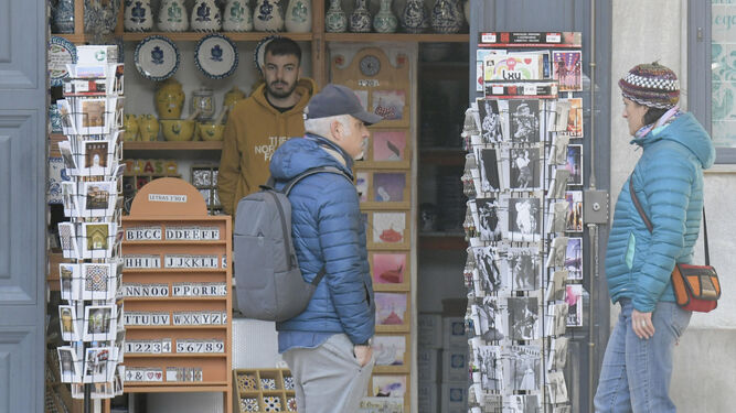 Dos turistas miran el escaparate de una tienda de recuerdos de Granada