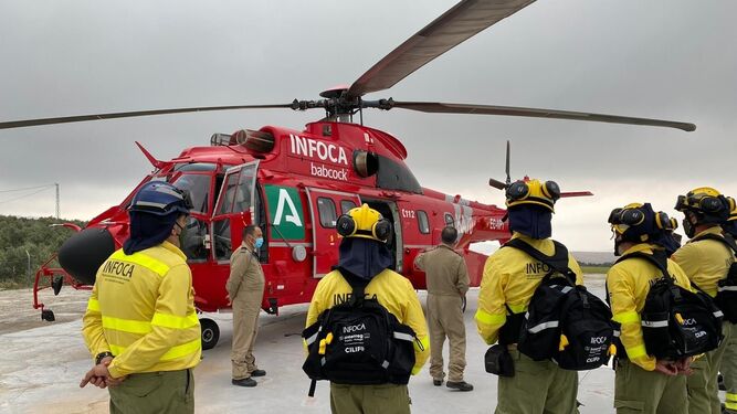 Imagen de archivo de un grupo de bomberos del Infoca y un helicóptero