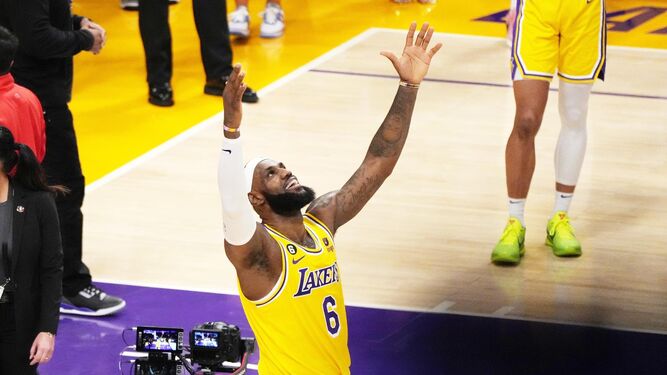 LeBron James alza los brazos tras superar la marca histórica de puntos.