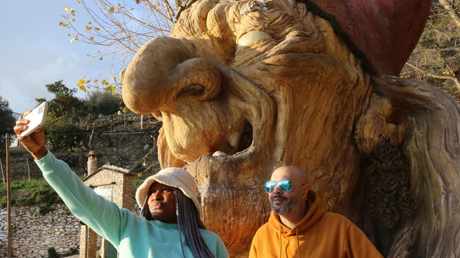 Dos turistas se fotografían frente a la cabeza de una bruja a la entrada de Soportujar