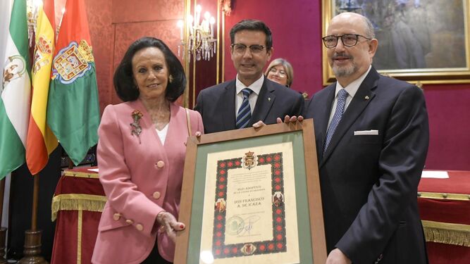 Sonsoles y Carlos, nietos, reciben el diploma de manos del alcalde de Granada.