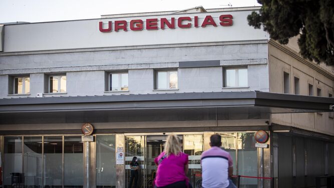 Dos personas esperan ante la entrada de Urgencias de un hospital de Granada.