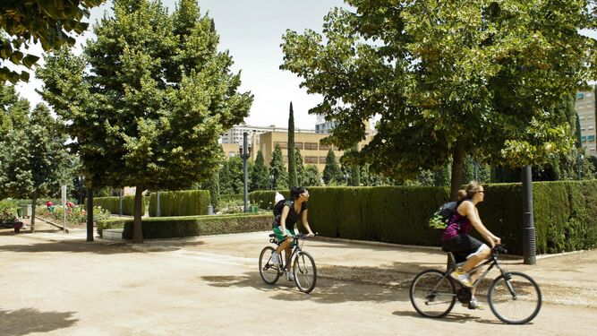 Dos ciclistas pasean por el Parque Federico García Lorca, uno de los puntos verdes más grandes de Granada