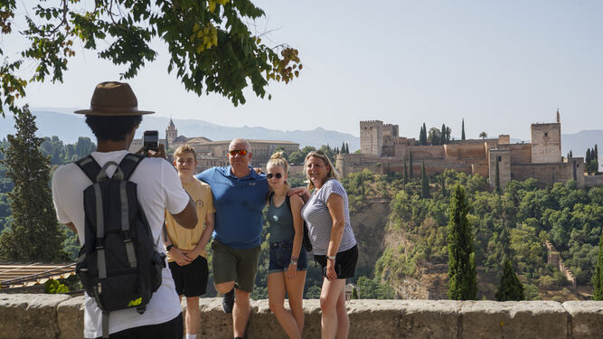 Un grupo de turistas se fotografía en el Mirador de San Nicolás de Granada, con la Alhambra a sus espaldas