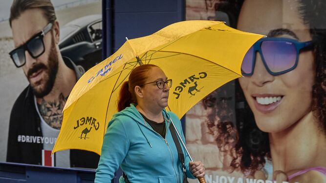 Una mujer se protege con un paraguas de la lluvia.