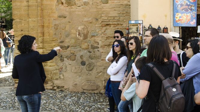 Visitantes a la Alhambra reciben indicaciones de una guía turística