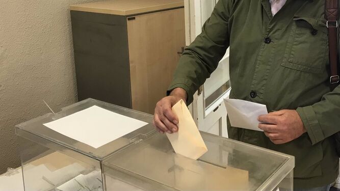 Un hombre deposita su voto en una urna en unas elecciones