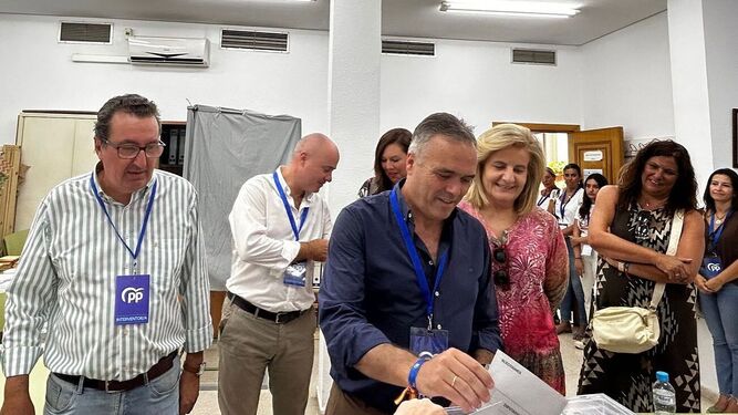 Manuel Andrés González y Fátima Báñez arropan a Manuel García Félix mientras vota en La Palma, feudo popular.