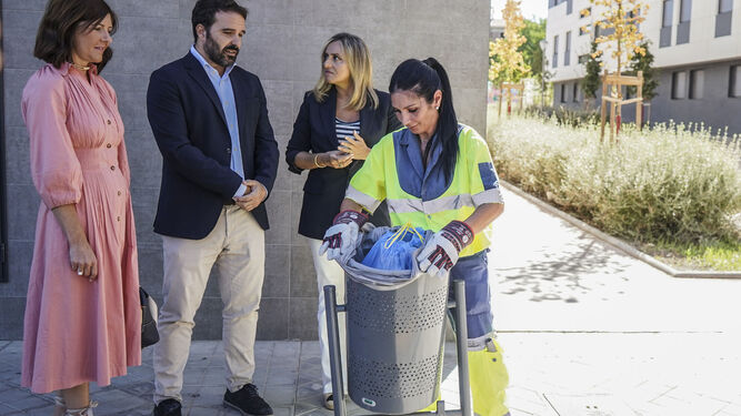 Una operaria retira la bolsa de una papelera de la capital bajo la mirada de la alcaldesa de Granada